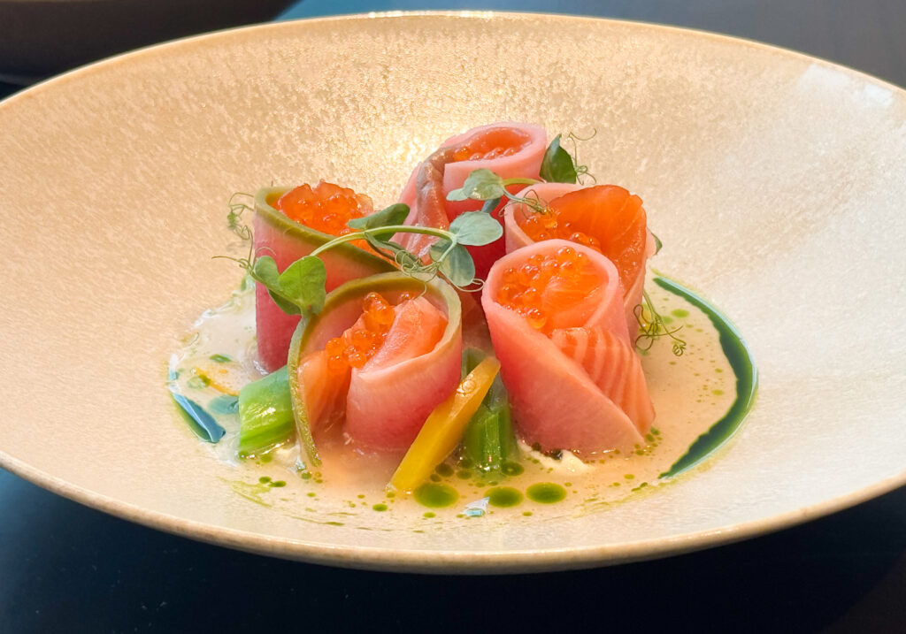 前菜の「タスマニア産サーモンのグラブラックス サーモンコンソメ 春野菜」